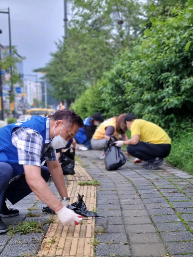땀흘리며 잡초를 제거하는 송산3동 자생단체 회원들 모습